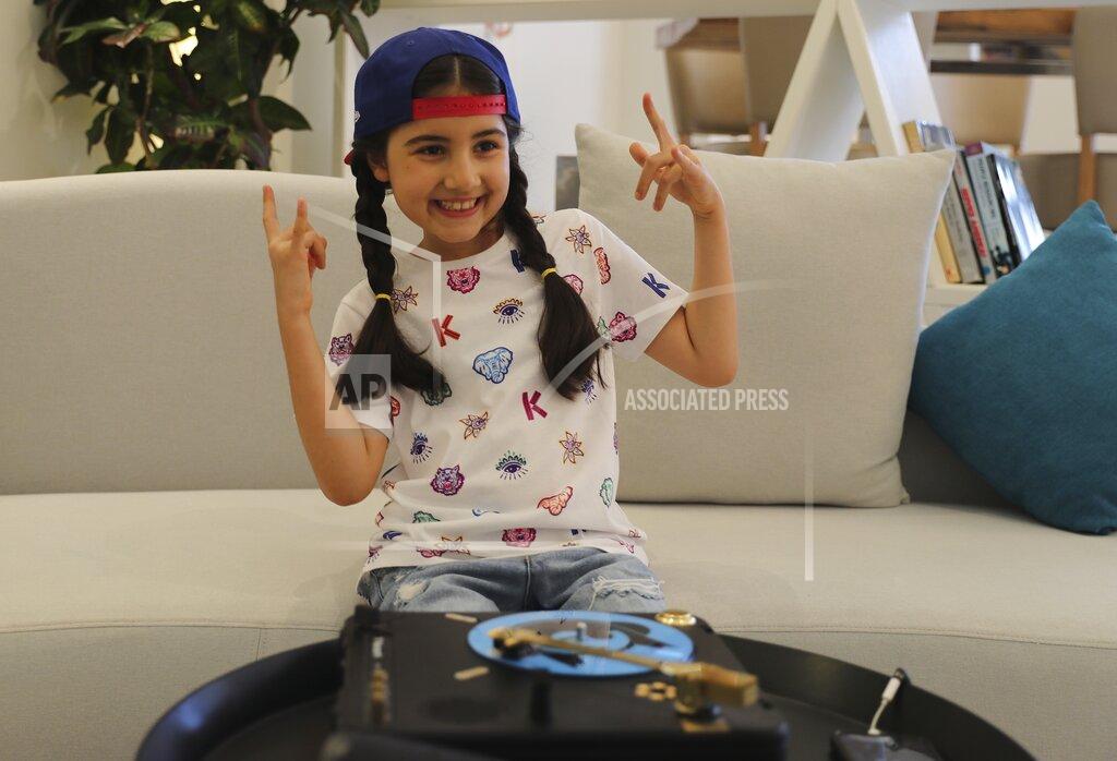 Kamran Jebreili Michelle Rasul flashes a rockstar sign in the lobby of her apartment building in Dubai, United Arab Emirates, Sunday, May 9, 2021. Rasul, a 9-year-old girl from Azerbaijan who lives in Dubai, is scratching her way to the top as a DJ after competing in the DMC World DJ Championship. (AP Photo/Kamran Jebreili)