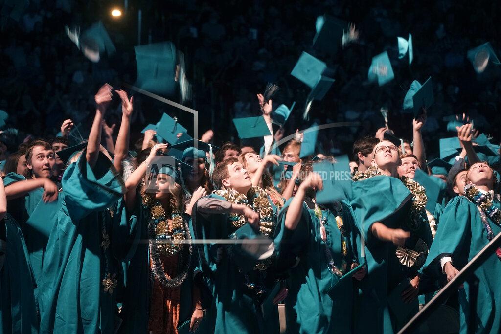 Rick Bowmer Graduates celebrate as they throw their caps in the air after the Canyon View High School graduation Wednesday, May 25, 2022, in Cedar City, Utah. (AP Photo/Rick Bowmer)