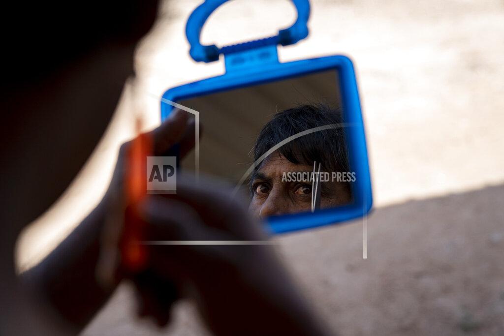 Ore Huiying A migrant worker trims his eyebrows at his living quarters on a palm oil plantation run by government-owned Felda in Malaysia in early 2020. Jum, a former worker who escaped from this same plantation, described to The Associated Press how the company confiscated and later lost his Indonesian passport, leaving him vulnerable to arrest and forcing him to hide in the jungle. (AP Photo/Ore Huiying)