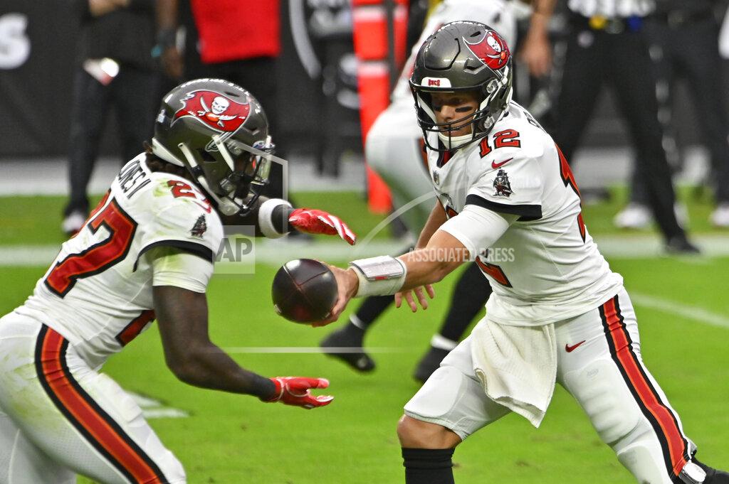 David Becker Tampa Bay Buccaneers quarterback Tom Brady (12) hands off the ball to running back Ronald Jones (27) during the first half of an NFL football game against the Las Vegas Raiders, Sunday, Oct. 25, 2020, in Las Vegas. (AP Photo/David Becker)