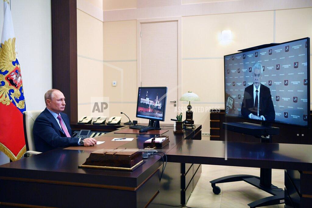 Russian President Vladimir Putin listens to Moscow Mayor Sergei Sobyanin during their meeting via teleconference at the Novo-Ogaryovo residence outside Moscow, Russia, Wednesday, May 27, 2020. (Alexei Nikolsky, Sputnik, Kremlin Pool Photo via AP)