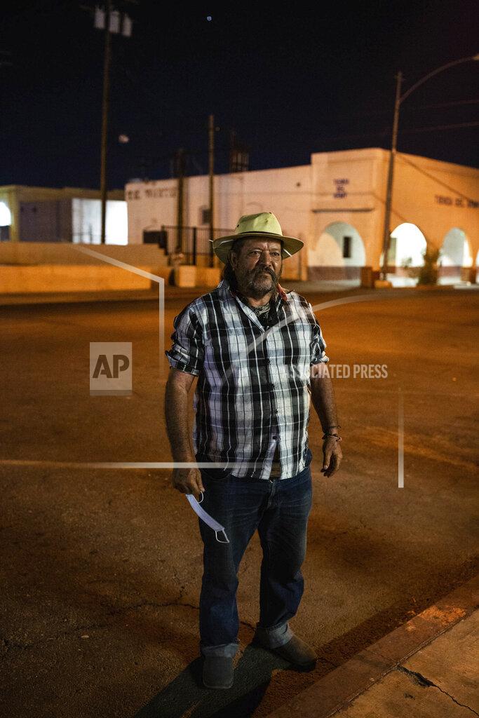 Anna Maria Barry-Jester Sergio Gomes Macias stands on street in Calexico, Calif., on July 23, 2020. Macias is a farmworker who sleeps on the street about 500 feet from the Mexican border. He says the pandemic has made it hard to find food, water and restrooms since nonessential businesses closed amid high infection rates in the area. Many homeless people work low-wage essential jobs on the front lines of the pandemic, putting them at higher risk of catching and possibly transmitting the virus. Many who work with these communities are reluctant to speak about this risk for fear of further stigmatizing homeless people, even though they do the front-line jobs others can avoid. (Anna Maria Barry-Jester/KHN and the Howard Center For Investigative Journalism via AP)