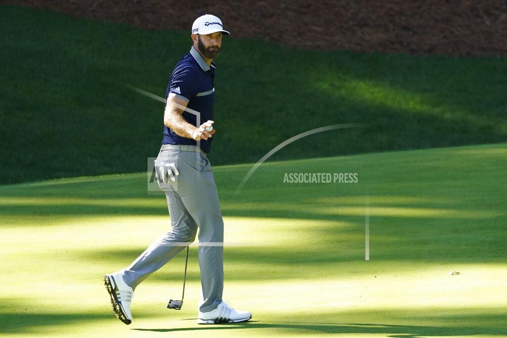 David J. Phillip Dustin Johnson holds up is ball after a birdie on the 13th hole during the second round of the Masters golf tournament Friday, Nov. 13, 2020, in Augusta, Ga. (AP Photo/David J. Phillip)