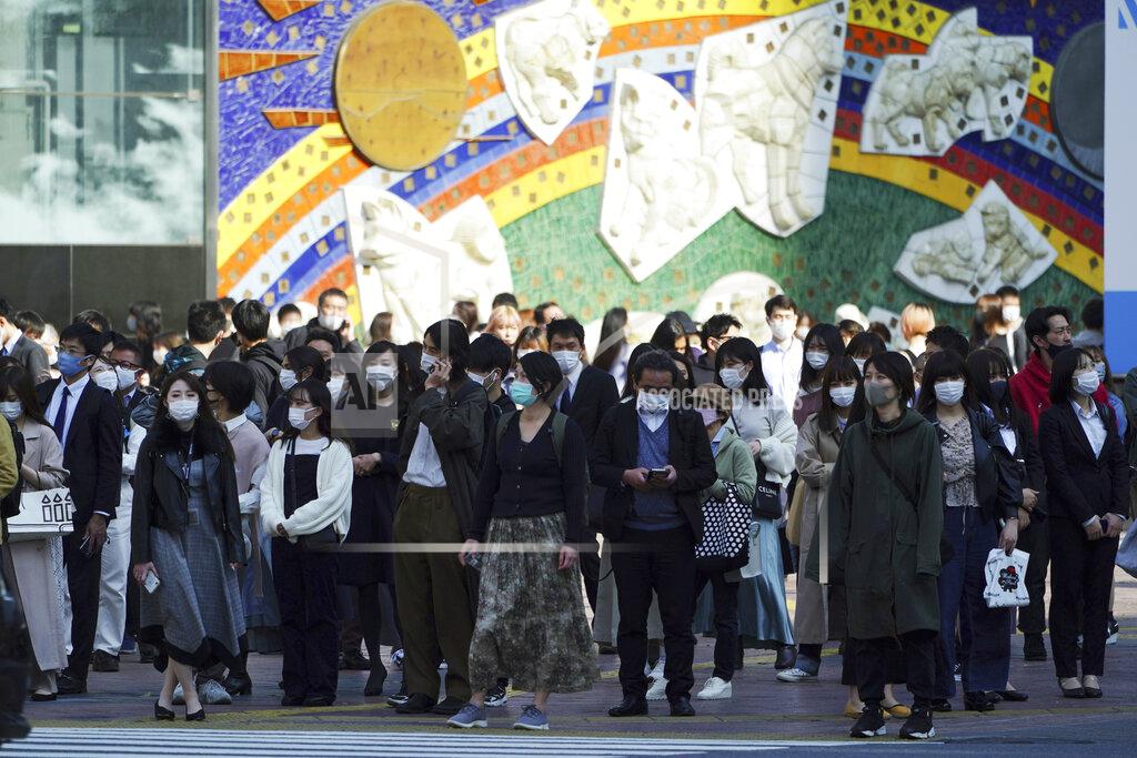 People wearing protective masks to help curb the spread of the coronavirus walk along a pedestrian crossing in Shibuya district in Tokyo on April 7, 2021. Japan is set to strengthen anti-virus measures in Tokyo on Friday, April 9, 2021 to curb the rapid spread of a more contagious coronavirus variant just three months before the Olympics begin in the capital where most people are not yet vaccinated. (AP Photo/Eugene Hoshiko)