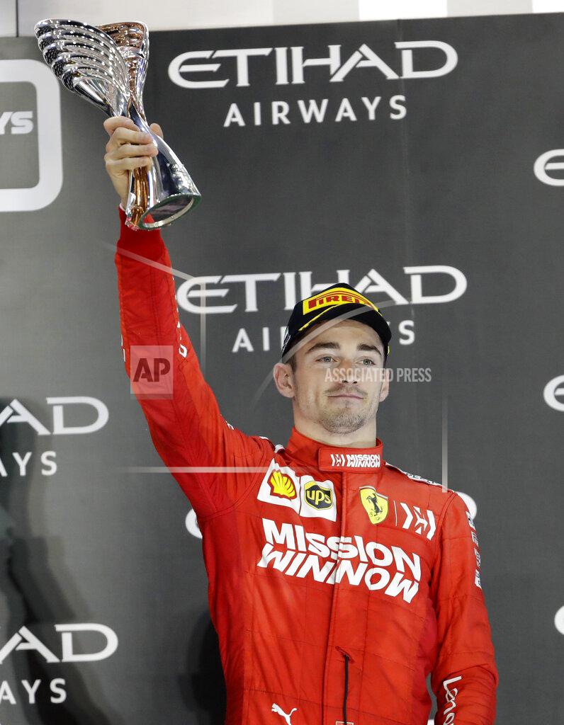 Luca Bruno Ferrari driver Charles Leclerc of Monaco holds the trophy on the podium after he placed third in the Emirates Formula One Grand Prix, at the Yas Marina racetrack in Abu Dhabi, United Arab Emirates, Sunday, Dec.1, 2019. (AP Photo/Luca Bruno)