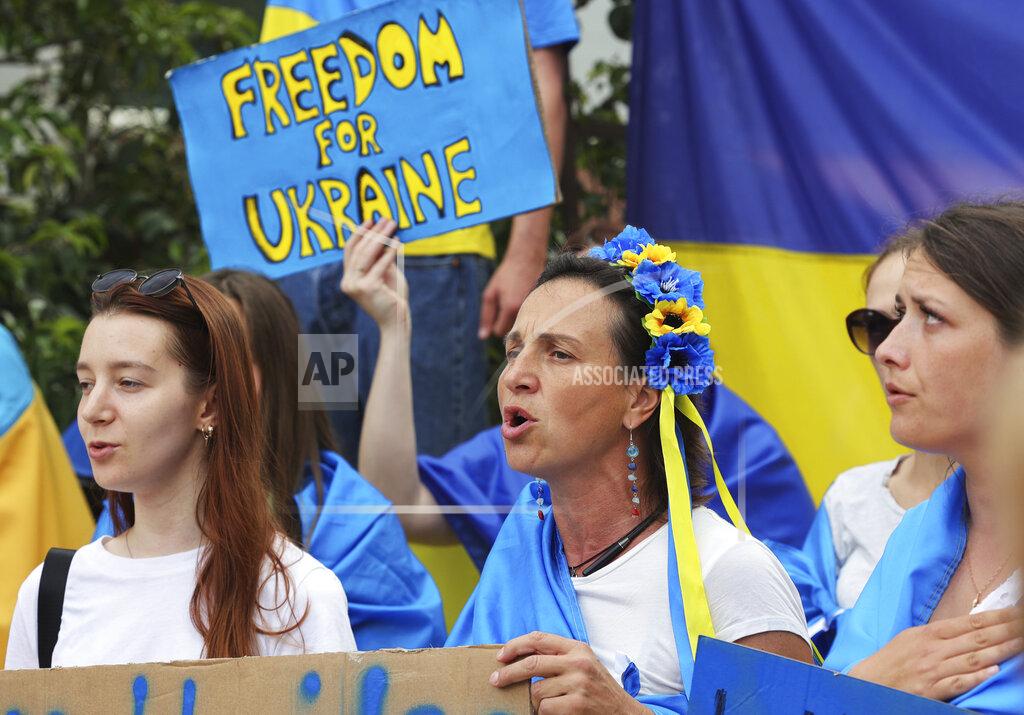 Olivier Matthys Protestors in support of Ukraine stand with signs and flags during a demonstration outside of an EU summit in Brussels, Thursday, June 23, 2022. European Union leaders are expected to approve Thursday a proposal to grant Ukraine a EU candidate status, a first step on the long toward membership. (AP Photo/Olivier Matthys)