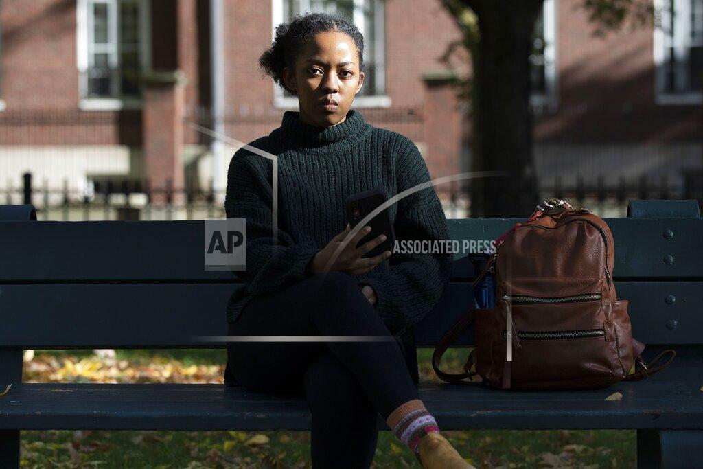 Harvard University graduate student Maya James poses in a park near the university, Wednesday, Oct. 14, 2020, in Cambridge, Mass. Law enforcement and voting advocates are warning that con artists are exploiting the election with scams targeting voters. James received an email from a political action committee that seemed harmless: if you support Joe Biden, it urged, click here to check you're registered to vote. Instead, she Googled the name of the group and it didn’t exist - a clue the email was a phishing scam. (AP Photo/Michael Dwyer)
