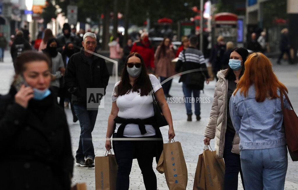 Frank Augstein People walk down a shopping street in Liverpool, England, Wednesday, Oct. 14, 2020. As the first area in England slapped with strict new restrictions to curb the resurgent coronavirus that have shuttered pubs and imperiled thousands of jobs, Liverpool again feels it's being punished by policies made in Britain's capital, 180 miles (290 kilometers) to the south. (AP Photo/Frank Augstein)
