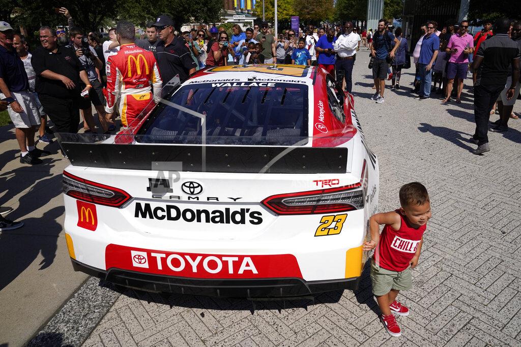 Charles Rex Arbogast Two-year-old Brooks Elmendorf, from Dallas, touches a car as Bubba Wallace, back to camera, stands on the other side of it at Navy Pier on Tuesday, July 19, 2022, in Chicago, during a promotion for a Cup Series street race to be held in the city, July 2, 2023. (AP Photo/Charles Rex Arbogast)
