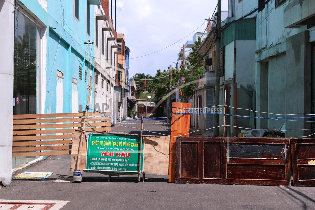 Hau Dinh An alley is barricaded with door panels in Vung Tau, Vietnam, Monday, Sept. 20, 2021. In Vung Tau, just outside Ho Chi Minh city, streets are sealed and checkpoints are set up to control the movement of people. Barbed wire, door panels, steel sheets, chairs and tables are among materials being used to fence up alleys and isolate neighborhoods.(AP Photo/Hau Dinh)