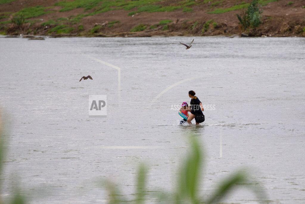 Dario Lopez-Mills A woman and a child cross the Rio Grande river towards the U.S. in Eagle Pass, Texas, Sunday May 22, 2022. Little has changed in what has quickly become one of the busiest corridors for illegal border crossings since a federal judge blocked pandemic-related limits on seeking asylum from ending Monday. (AP Photo/Dario Lopez-Mills)