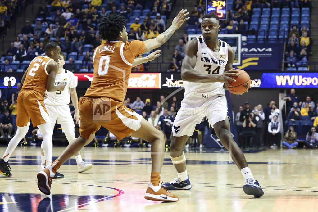 Kathleen Batten West Virginia forward Oscar Tshiebwe (34) goes to pass the ball as he is defended by Texas forward Gerald Liddell (0) during the second half of an NCAA college basketball game Monday, Jan. 20, 2020, in Morgantown, W.Va. (AP Photo/Kathleen Batten)