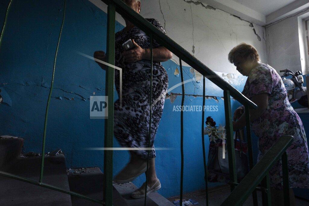 Nariman El-Mofty 64-year-old Tetiana Solohub, left, walks up with her friend to see her apartment destroyed from Russian aerial bombs, in Borodyanka, Kyiv region, Ukraine, Tuesday, June 28, 2022. "And now, at 64, I am forced to be homeless," Solohub said. She doesn't have a damaged apartment to live in. Hers is completely gone. Solohub now lives in a camp made of shipping containers. (AP Photo/Nariman El-Mofty)