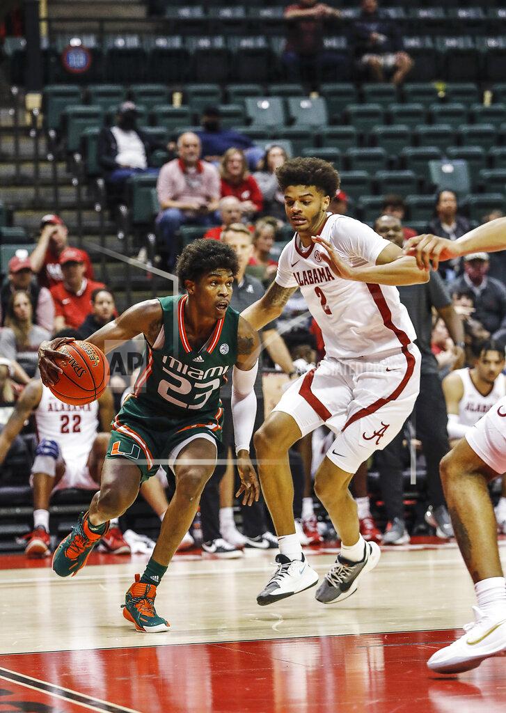 Jacob M. Langston Miami guard Kameron McGusty drives to the basket in front of Alabama forward Darius Milesduring the first half of an NCAA college basketball game Sunday, Nov. 28, 2021, in Lake Buena Vista, Fla. (AP Photo/Jacob M. Langston)