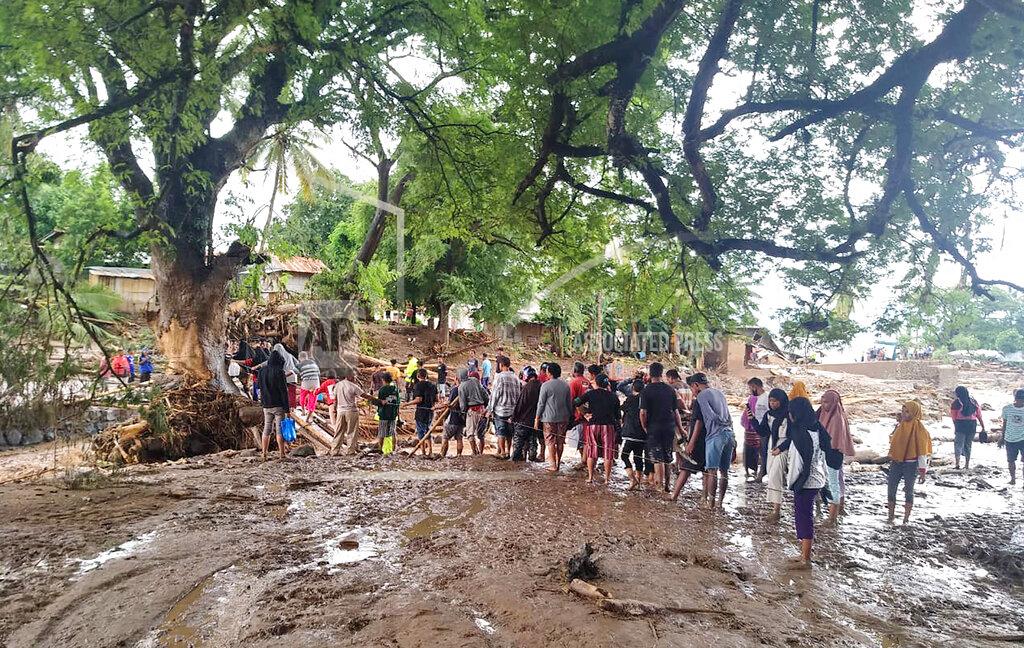 Rofinus Monteiro People queue up to cross a makeshift bridge at a village affected by floods on Adonara Island, East Flores, Indonesia, Monday, April 5, 2021. Multiple disasters caused by torrential rains in eastern Indonesia and neighboring East Timor have left a number of people dead or missing as rescuers were hampered by damaged bridges and roads and a lack of heavy equipment Monday. (AP Photo/Rofinus Monteiro)