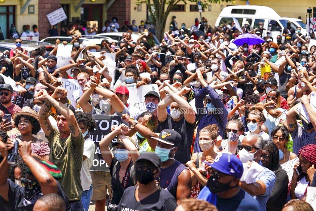 Martha Asencio-Rhine Demonstrators use hand signals during while marching near Cyrus Greene Park Sunday, May 31, 2020 in Tampa, Fla. For a second day in a row protestors took to the streets of Tampa to protest the Memorial Day death of George Floyd in Minneapolis. (Martha Asencio-Rhine/Tampa Bay Times via AP)