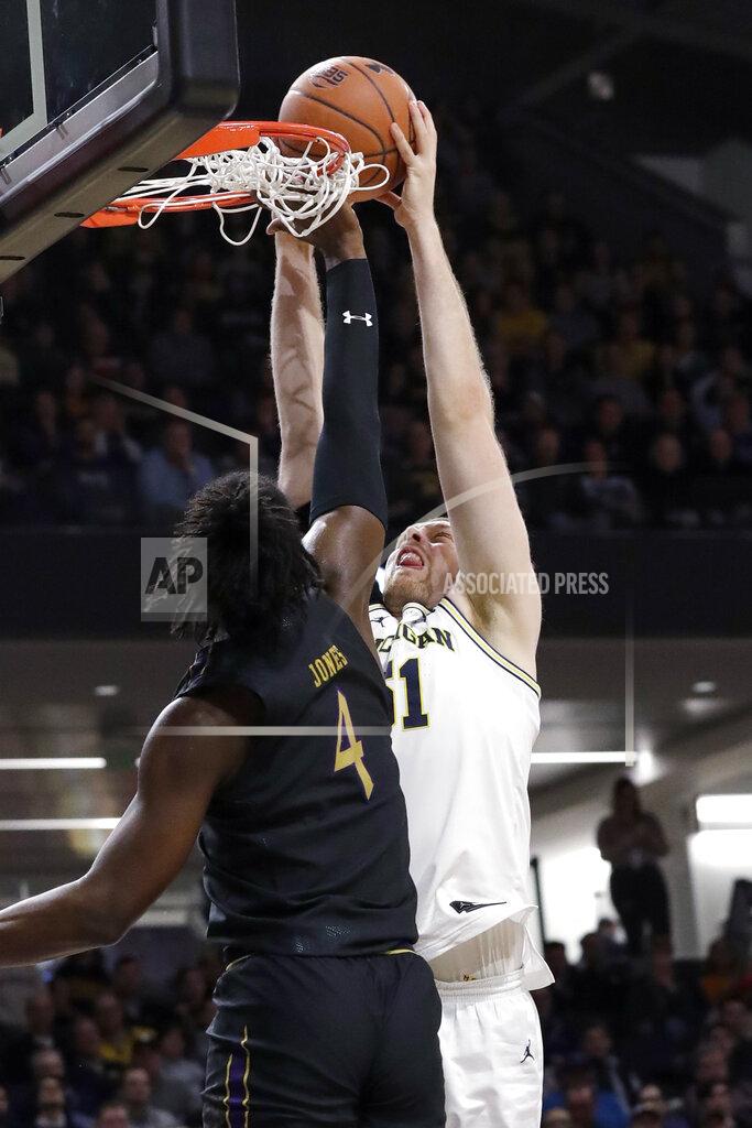 Nam Y. Huh Michigan forward Austin Davis, right, dunks against Northwestern forward Jared Jones during the first half of an NCAA college basketball game in Evanston, Ill., Wednesday, Feb. 12, 2020. (AP Photo/Nam Y. Huh)