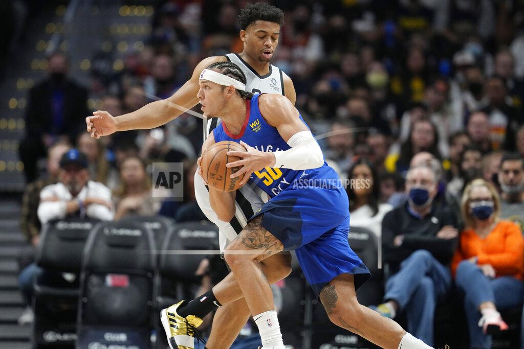 David Zalubowski Denver Nuggets forward Aaron Gordon, front, drives past San Antonio Spurs forward Keldon Johnson during the first half of an NBA basketball game Friday, Oct. 22, 2021, in Denver. (AP Photo/David Zalubowski)