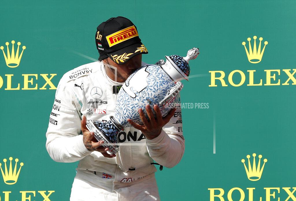 Laszlo Balogh Mercedes driver Lewis Hamilton of Britain kisses the trophy as he celebrates on the podium after winning the Hungarian Formula One Grand Prix at the Hungaroring racetrack in Mogyorod, northeast of Budapest, Hungary, Sunday, Aug. 4, 2019. (AP Photo/Laszlo Balogh)