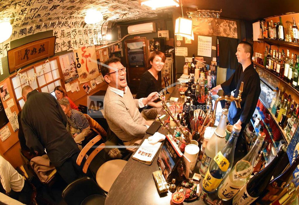 Malcolm Foster In this March 5, 2020 photo, customers laugh at the Vowz Bar, run by Buddhist priests, in downtown Tokyo. Buddhism suffers from a gloomy image in Japan given its close link to funerals, but some younger priests are trying to rejuvenate the religion by making it more appealing and relevant to daily life through activities such as traditional story-telling, contemporary music, TV show appearances, counseling people considering suicide and hosting customers at such "monk bars." (AP Photo/Malcolm Foster)