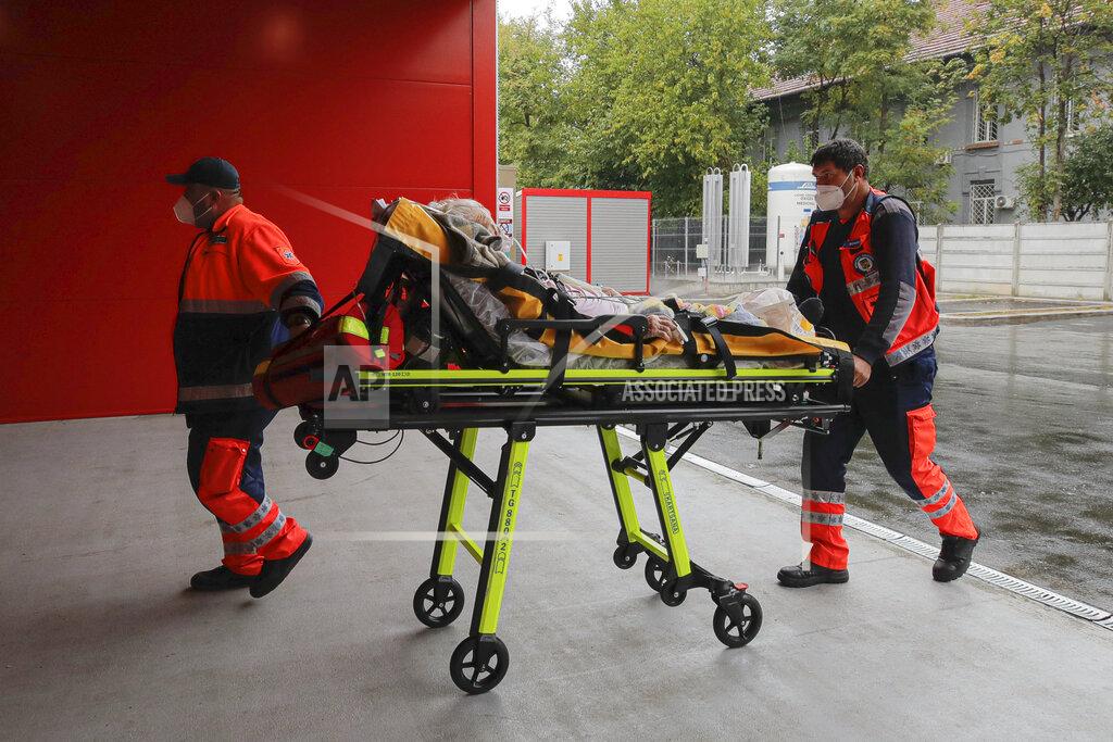 Andreea Alexandru Paramedics bring an elderly patient to the emergency room, turned into a CODIV-19 unit due the high number of cases, at the Bagdasar-Arseni hospital in Bucharest, Romania, Tuesday, Oct. 12, 2021. Romania reported on Tuesday nearly 17,000 new COVID-19 infections and 442 deaths, the highest number of coronavirus infections and deaths in a day since the pandemic started, as the nation's health care system struggles to cope with an acute surge of new cases.(AP Photo/Andreea Alexandru)