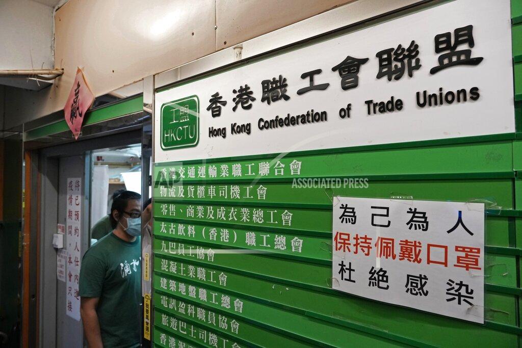 Vincent Yu A member of the Hong Kong Confederation of Trade Unions stands at the entrance before a news conference on the possibility of disbandment in Hong Kong Sunday, Sept. 19, 2021. Hong Kong's biggest opposition trade union said Sunday it would disband, following concerns for "members' personal safety." (AP Photo/Vincent Yu)
