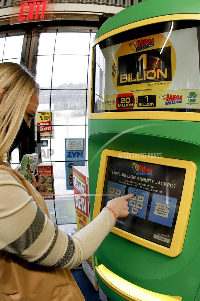 Keith Srakocic A patron, who did not want to give her name, uses the lottery ticket vending kiosk at a Smoker Friendly store to purchase tickets for the Mega Millions lottery drawing, Friday, Jan. 22, 2021, in Cranberry Township, Pa. The jackpot for the Mega Millions lottery game has grown to $1 billion ahead of Friday night's drawing after more than four months without a winner. (AP Photo/Keith Srakocic)