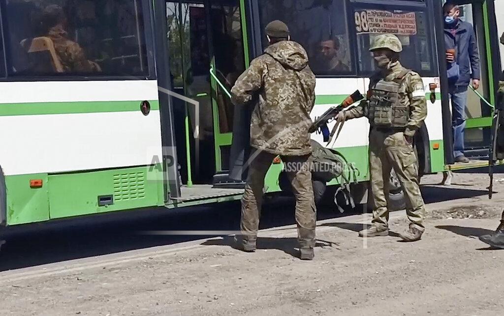 Uncredited In this photo taken from video released by the Russian Defense Ministry Press Service on Wednesday, May 18, 2022, Russian servicemen watch Ukrainian servicemen boarding a bus after they leaved the besieged Azovstal steel plant in Mariupol, Ukraine.(Russian Defense Ministry Press Service via AP)