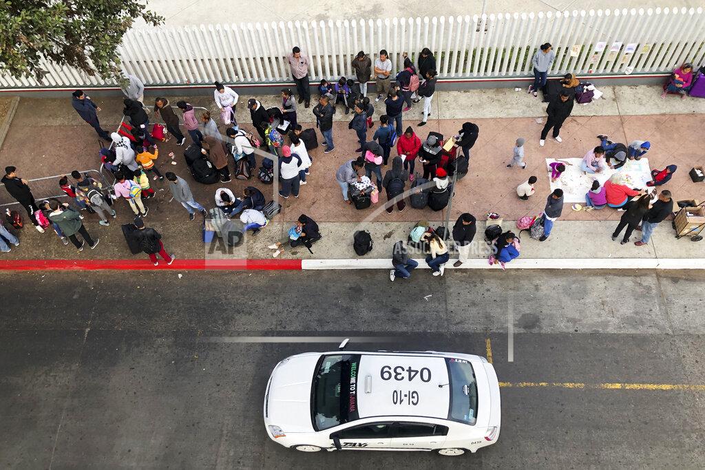 Elliot Spagat FILE - In this Nov. 10, 2019, file photo, migrants gather at the U.S.-Mexico border in Tijuana, Mexico, to hear names called from a waiting list to claim asylum in the U.S. U.S. authorities wield extraordinary power available in public health emergencies, like the coronavirus pandemic, to expel Mexicans and many Central Americans immediately to Mexico and waive immigration laws that include rights to seek asylum. (AP Photo/Elliot Spagat, File)