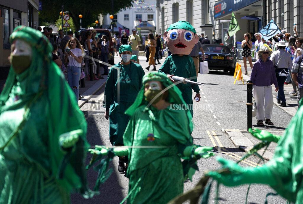Alberto Pezzali Climate activists and others hold signs and banners as they march in costume through the streets during a demonstration around the meeting of the G7 in Falmouth, Cornwall, England, Saturday, June 12, 2021. Leaders of the G7 gather for a second day of meetings on Saturday, in which they will discuss COVID-19, climate, foreign policy and the economy. (AP Photo/Alberto Pezzali)
