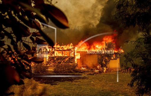 Flames consume a house near Old Oregon Trail as the Fawn Fire burns north of Redding in Shasta County, Calif., on Thursday, Sept. 23, 2021. (AP Photo/Ethan Swope)
