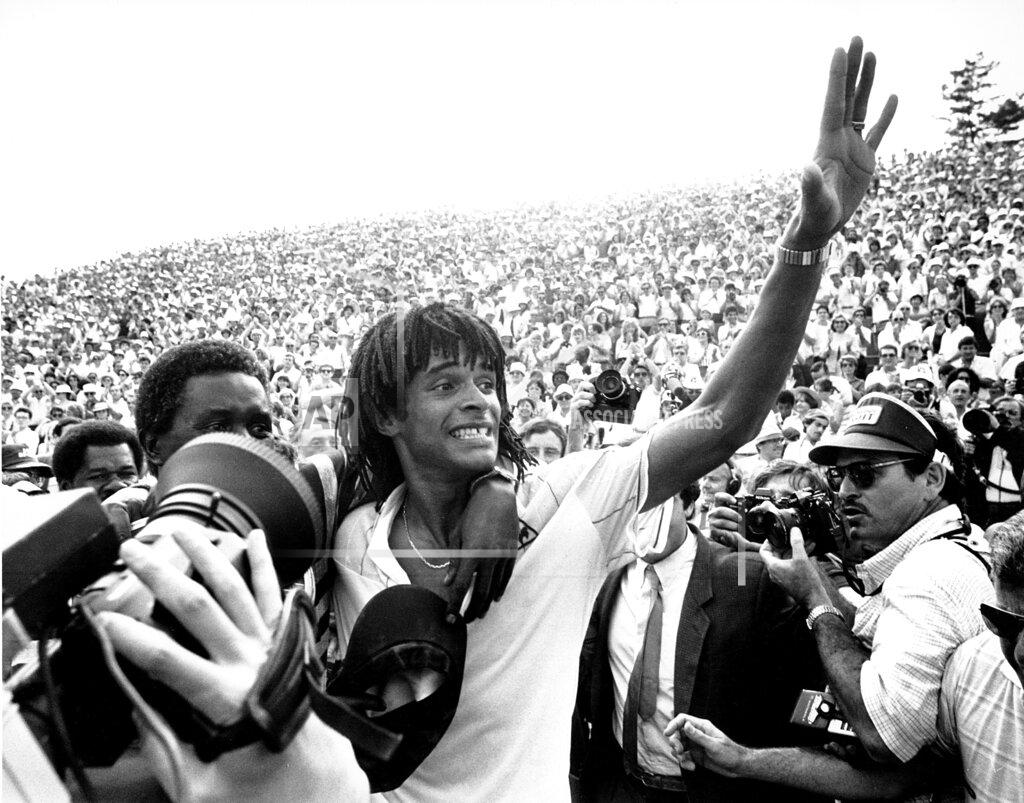 Jacques Langevin FILE - In this June 5, 1983, file photo, Yannick Noah, of France, waves to the crowd at Roland Garros stadium in Paris after defeating Sweden's Mats Wilander to win the French Open men's singles tennis title. Obscured at left hugging Yannick Noah is his father. Noah is the only Frenchman since 1946 to win his country's tournament. (AP Photo/Jacques Langevin, File)