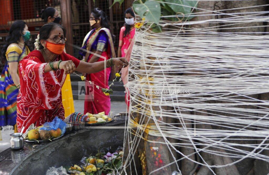 Rajanish Kakade A woman perform rituals with ceremonial thread around a banyan tree on Vat Savitri festival in Mumbai, India, Friday, June 5, 2020. Vat Savitri is celebrated on a full moon day where women pray for the longevity of their husbands. (AP Photo/Rajanish Kakade)
