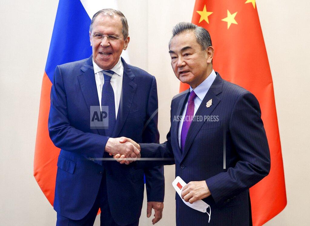 Uncredited In this handout photo released by Russian Foreign Ministry Press Service, Russian Foreign Minister Sergey Lavrov, left, shakes hands with Chinese Foreign Minister Wang Yi during their bilateral meeting ahead of the G20 Foreign Ministers' Meeting in Nusa Dua, Bali, Indonesia, Thursday, July 7, 2022. (Russian Foreign Ministry Press Service via AP)