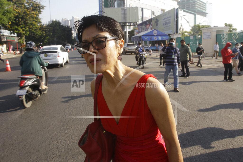 Theary Seng, a Cambodian-American lawyer, stands near the Phnom Penh Municipal Court in Phnom Penh, Cambodia, Thursday, Jan. 14, 2021. Theary Seng said Thursday she was being persecuted for her political opinion as she and dozens of other government critics charged with treason and other offenses returned to court in a trial criticized by rights advocates. (AP Photo/Heng Sinith)