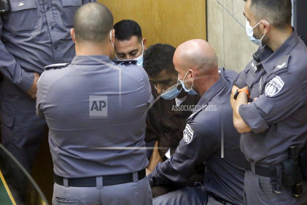 Sebastian Scheiner Zakaria Zubeidi, one of the six Palestinians who escaped from a high-security prison earlier this week is surrounded by guards as they stand in a courtroom in Nazareth, Israel, after he and three other Palestinian fugitives were captured on Saturday, Sept. 11, 2021. Israeli police on Saturday said they have arrested four of the six Palestinians who broke out of a maximum-security prison this week including Zubeidi a famed militant leader whose exploits over the years have made him a well-known figure in Israel. (AP Photo/Sebastian Scheiner)