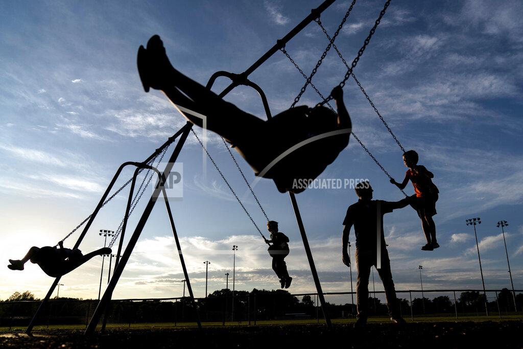 David Goldman State Republican Sen. Roger Roth, pushes his four sons on a park's swing set in Appleton, Wis., Aug. 19, 2020. Republicans here say there is proof that their playbook of aiding companies with tax breaks can protect jobs and provide a foundation for growth. They point to the saving of the nearby Kimberly-Clark plant in Cold Springs through tax incentives and union concessions. "It's bigger than just 400 jobs, it's the footprint of 198 other businesses, a whole ecosystem," Roth said. (AP Photo/David Goldman)