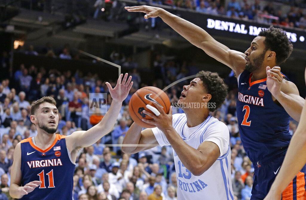 Gerry Broome North Carolina's Cameron Johnson (13) looks to shoot while Virginia's Ty Jerome (11) and Braxton Key (2) defend during the first half of an NCAA college basketball game in Chapel Hill, N.C., Monday, Feb. 11, 2019. (AP Photo/Gerry Broome)
