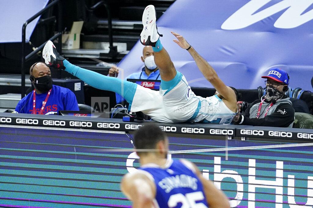 Matt Slocum Charlotte Hornets' Caleb Martin, top, flies on top of the scorers table after chasing a loose ball during the first half of an NBA basketball game against the Philadelphia 76ers, Monday, Jan. 4, 2021, in Philadelphia. (AP Photo/Matt Slocum)
