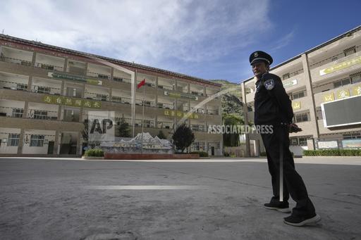 A security guard stands watch at the Shangri-La Key Boarding School during a media-organized tour in Dabpa county, Kardze Prefecture, Sichuan province, China on Sept. 5, 2023. Village schools have been shuttered across China's Tibet and replaced with centralized boarding schools that critics say represents forced assimilation. Activists estimate 1 million Tibetan children study at such boarding school. (AP Photo/Andy Wong)