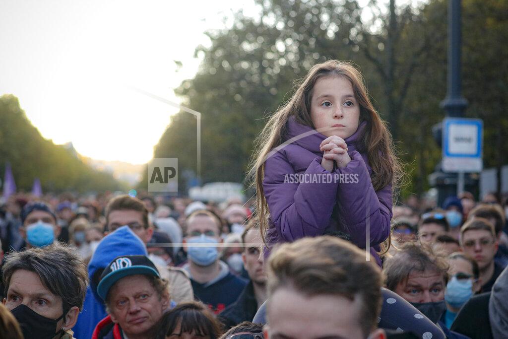 Laszlo Balogh A child sits on a man's shoulders as Hungarian opposition supporters listen to a speech by Prime Minister candidate Peter Marki-Zay during celebration the 65th anniversary of the 1956 Hungarian revolution, in Budapest, Hungary, Saturday, Oct. 23, 2021. Earlier thousands of supporters of Prime Minister Viktor Orban, who delivered a speech marking the 65th anniversary of the 1956 Hungarian revolution, marched to demonstrate loyalty to his right-wing government. (AP Photo/Laszlo Balogh)