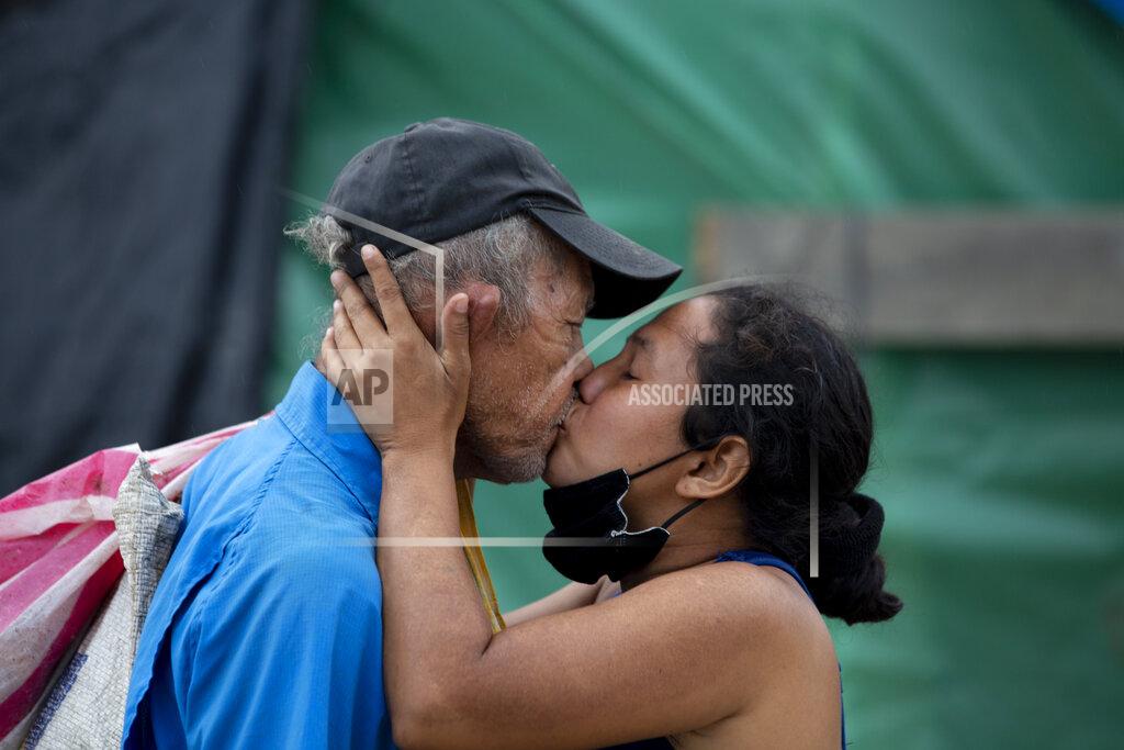 Moises Castillo A couple kiss at the shelter where they live since losing their home in last year's hurricanes Eta and Iota, in La Lima, on the outskirts of San Pedro Sula, Honduras, Monday, Jan. 11, 2021. The devastation wrought by November's hurricanes and the economic damage of the COVID-19 pandemic has added to the forces of poverty and gang violence that drive Hondurans to migrate. (AP Photo/Moises Castillo)
