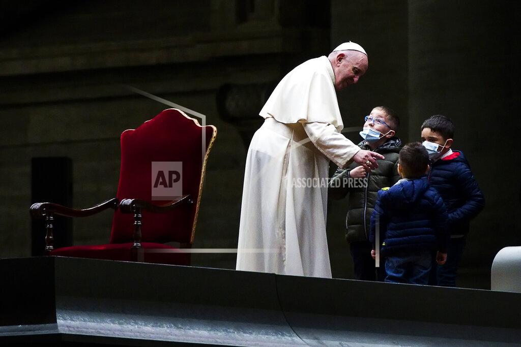 Pope Francis salutes some children after leading the Via Crucis (Way of the Cross) procession in the empty square outside the Saint Peter's Basilica during Good Friday celebrations at the Vatican, with no public participation due to the Coronavirus pandemic, Friday, April 2, 2021. (Angelo Carconi/Pool photo via AP)
