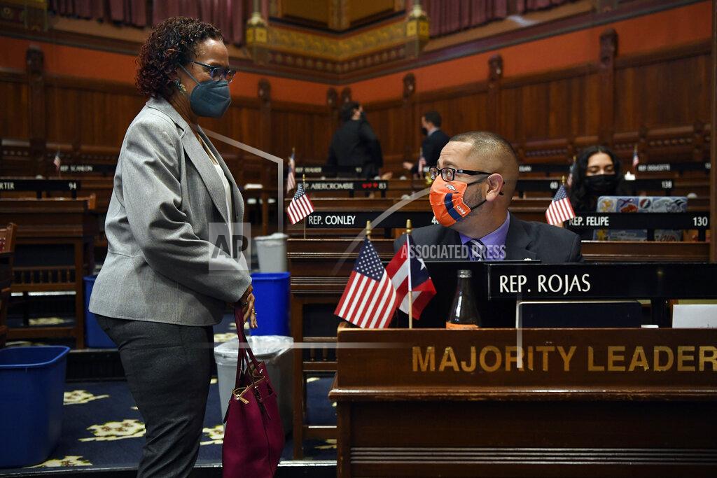 Jessica Hill Connecticut House Majority Leader Jason Rojas, D-East Hartford, right, speaks with State Rep. Toni Walker, D-New Haven, left, during session at the State Capitol in Hartford, Conn., on Monday, April 19, 2021. In July 2020 after George Floyd was killed in Minneapolis, Black and Latino members of the Connecticut General Assembly worked to enact sweeping changes to policing in the state, and since, have continue to flex their collective muscles. (AP Photo/Jessica Hill)