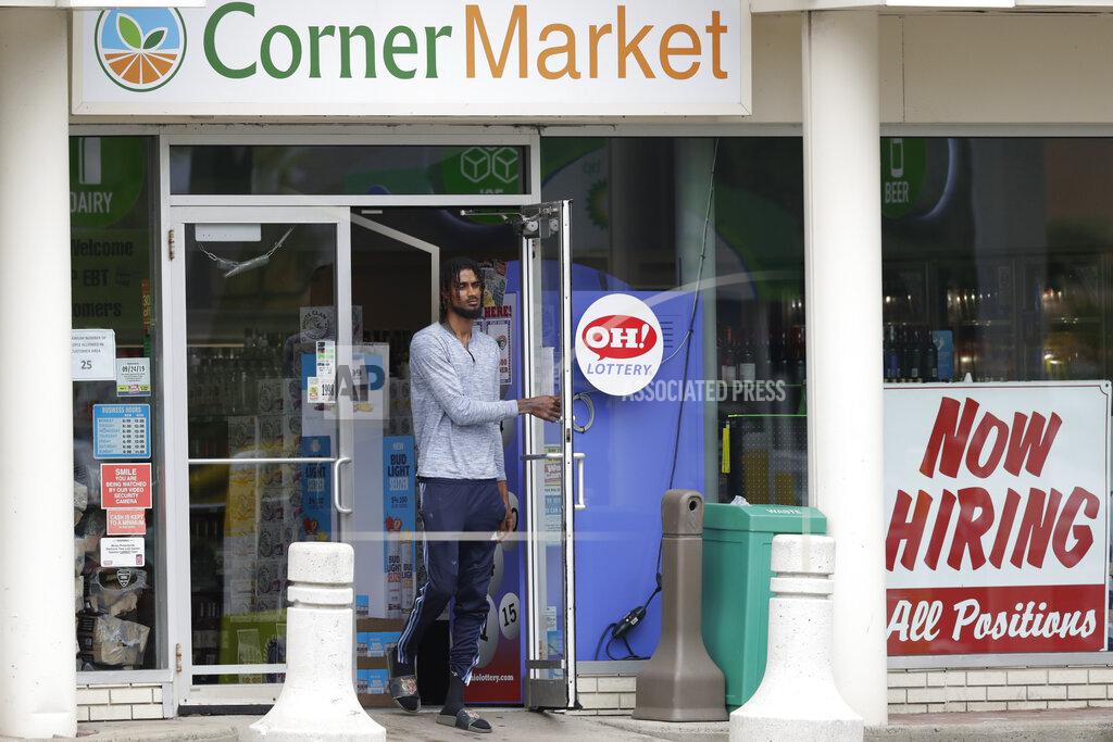 A sign "Now Hiring" rests in a window as a man walks out of the Corner Market, Thursday, May 28, 2020, in Lyndhurst, Ohio. The state says about 1.3 million Ohioans have filed unemployment claims in the past 10 weeks as Ohio's stay-at-home order depressed the economy and led to widespread layoffs. The Ohio Department of Job and Family Services says about 42,000 people filed claims for the week ending May 23. (AP Photo/Tony Dejak)
