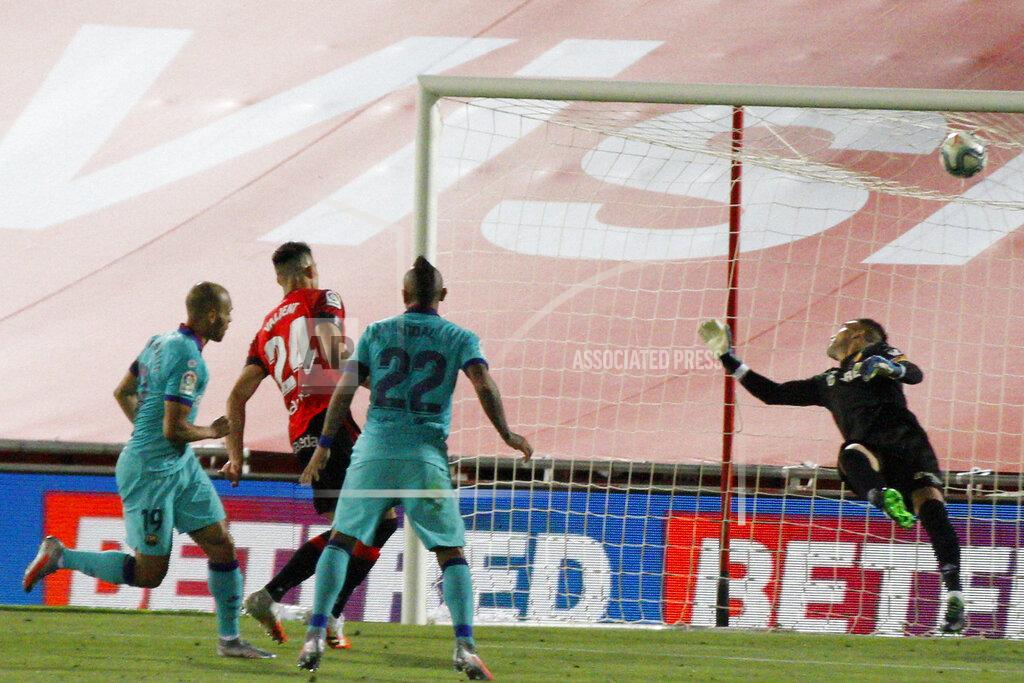 Francisco Ubilla FC Barcelona's Martin Braithwaite, left, scores his side's second goal during the Spanish La Liga soccer match between Mallorca and FC Barcelona at Son Moix Stadium in Palma de Mallorca, Spain, Saturday, June 13, 2020. With virtual crowds, daily matches and lots of testing for the coronavirus, soccer is coming back to Spain. The Spanish league resumes this week more than three months after it was suspended because of the COVID-19 pandemic. (AP Photo/Francisco Ubilla)