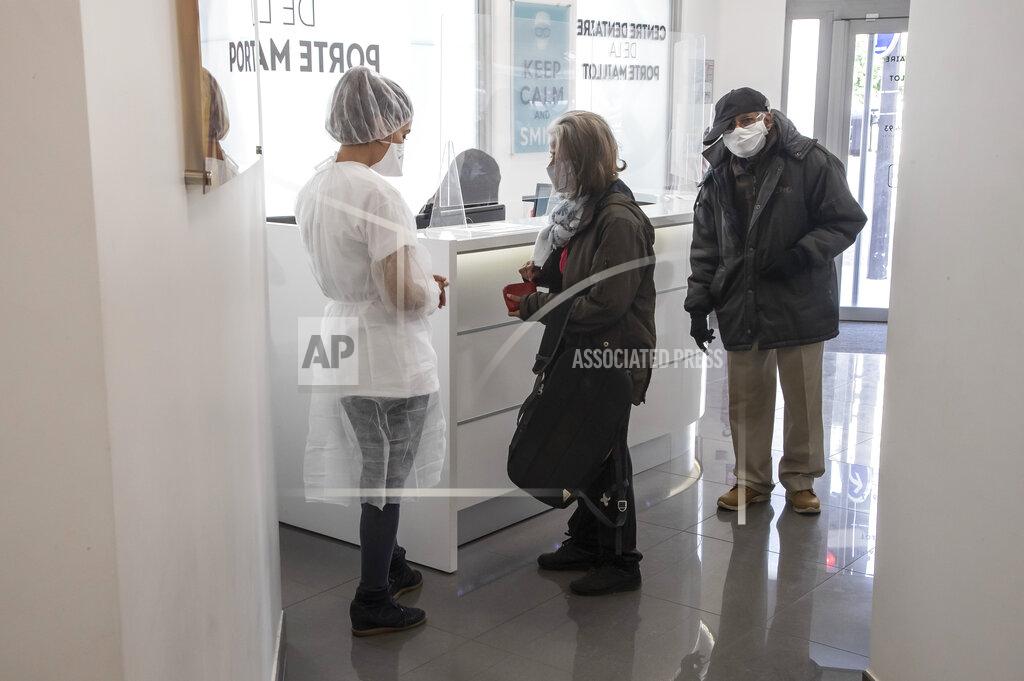 Michel Euler In this Wednesday, May 13, 2020 photo, dentist Sabrine Jendoubi, left, speaks to an unidentified patient upon her arrival at a dental office in Paris. Those with toothache that suffered through France's two-month lockdown, finally have hope to end the pain. Dental practices are cautiously re-opening and non-emergency dentist appointments are now permitted around the country, as the French government eased confinement restrictions from Monday. (AP Photo/Michel Euler)