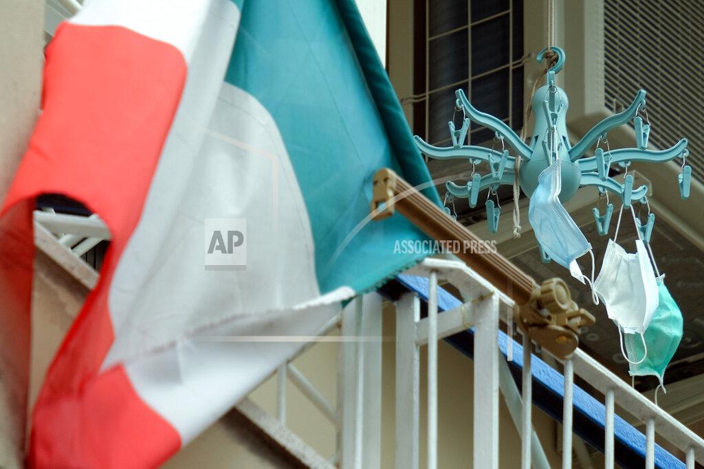 Mauro Scrobognae An Italian flag is hung outside a balcony along with some protective masks in Rome Thursday, April 23, 2020. The number of dead and new positives continues to plateau as Italy, the first western country to be hit by the coronavirus epidemic, in the seventh week of a nationwide lockdown following COVID-19 pandemic. (Mauro Scrobogna/LaPresse via AP)