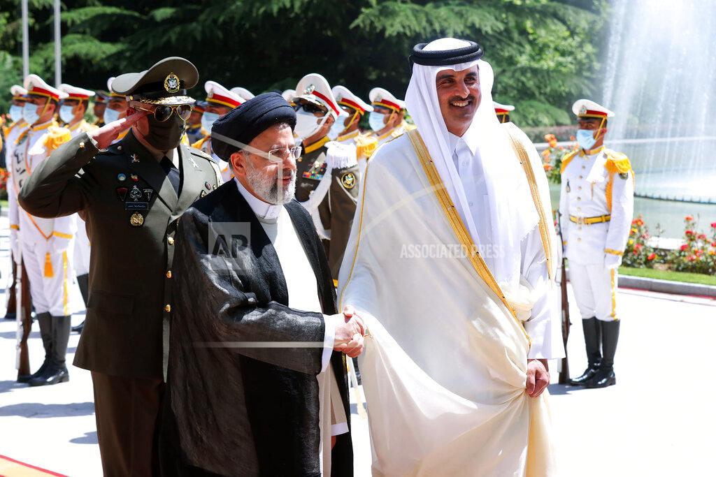 Uncredited In this photo released by the official website of the office of the Iranian Presidency, Qatari Emir Sheikh Tamim bin Hamad Al Thani, right, shakes hands with President Ebrahim Raisi during an official arrival ceremony at the Saadabad Palace in Tehran, Iran, Thursday, May 12, 2022. Qatar's emir arrived in Tehran for talks with the Iranian president as efforts to save Tehran's tattered nuclear deal with world powers hit a deadlock. (Iranian Presidency Office via AP)