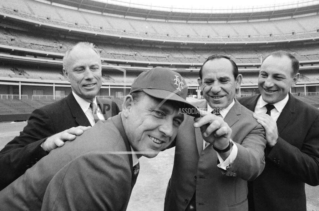 Harry Harris FILE - Gil Hodges, second from left, the new New York Mets manager, wears a team cap with an added touch by first base coach Yogi Berra, second from right, as Bing Devine, left, president of the team, and Joe Pignatano, right, newly signed as the team's bullpen coach, watch during a visit to Shea Stadium, Oct. 17, 1967, in New York. Pignatano, who made his major league debut with the Brooklyn Dodgers in 1957 and later was a coach for the Mets, died Monday, May 23, 2022, in Naples, Fla. (AP Photo/Harry Harris, File)